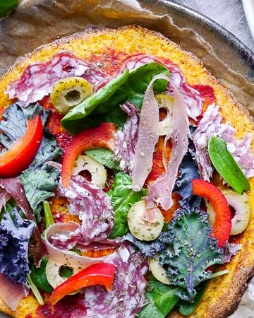 A healthy paleo pumpkin pizza crust recipe using mashed pumpkin, almond flour and psyllium husk. It's grain free and dairy free, and can be made vegan using a flax egg!