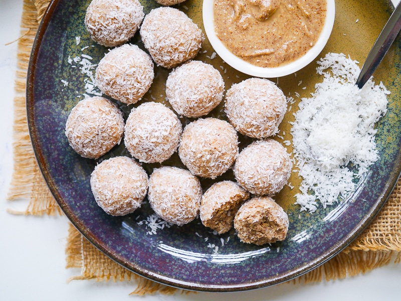 Protein balls rolled in desiccated coconut on a blue ceramic plate