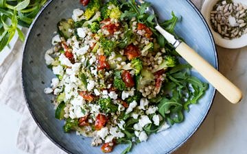 Broccoli Buckwheat Salad with chopped semi dried tomatoes topped with feta cheese in bowl - recipe by Nourish Every Day