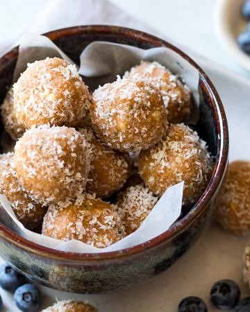 No food processor Paleo Protein Balls, all stacked in a bowl! Combining crunchy nut butter, coconut, hemp seeds, a little honey and your favourite protein powder.