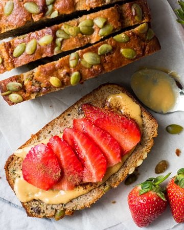 Slices of apple zucchini snack cake from top down, one flat topped with sliced strawberries
