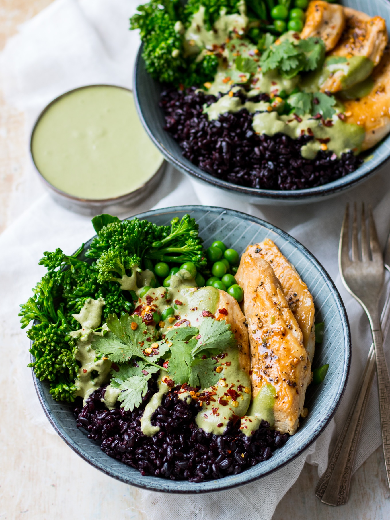 Blue bowls, chicken black rice bowls, layered with black rice, marinated chicken, peas, broccolini, green cashew herb sauce