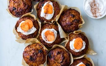 Healthy Carrot Cake Muffins, muffins clustered together on a marble surface, half iced with coconut yoghurt