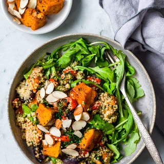 Honey roast pumpkin quinoa salad flatlay view, grey bowl, grey napkin, roast pumpkin in side dish