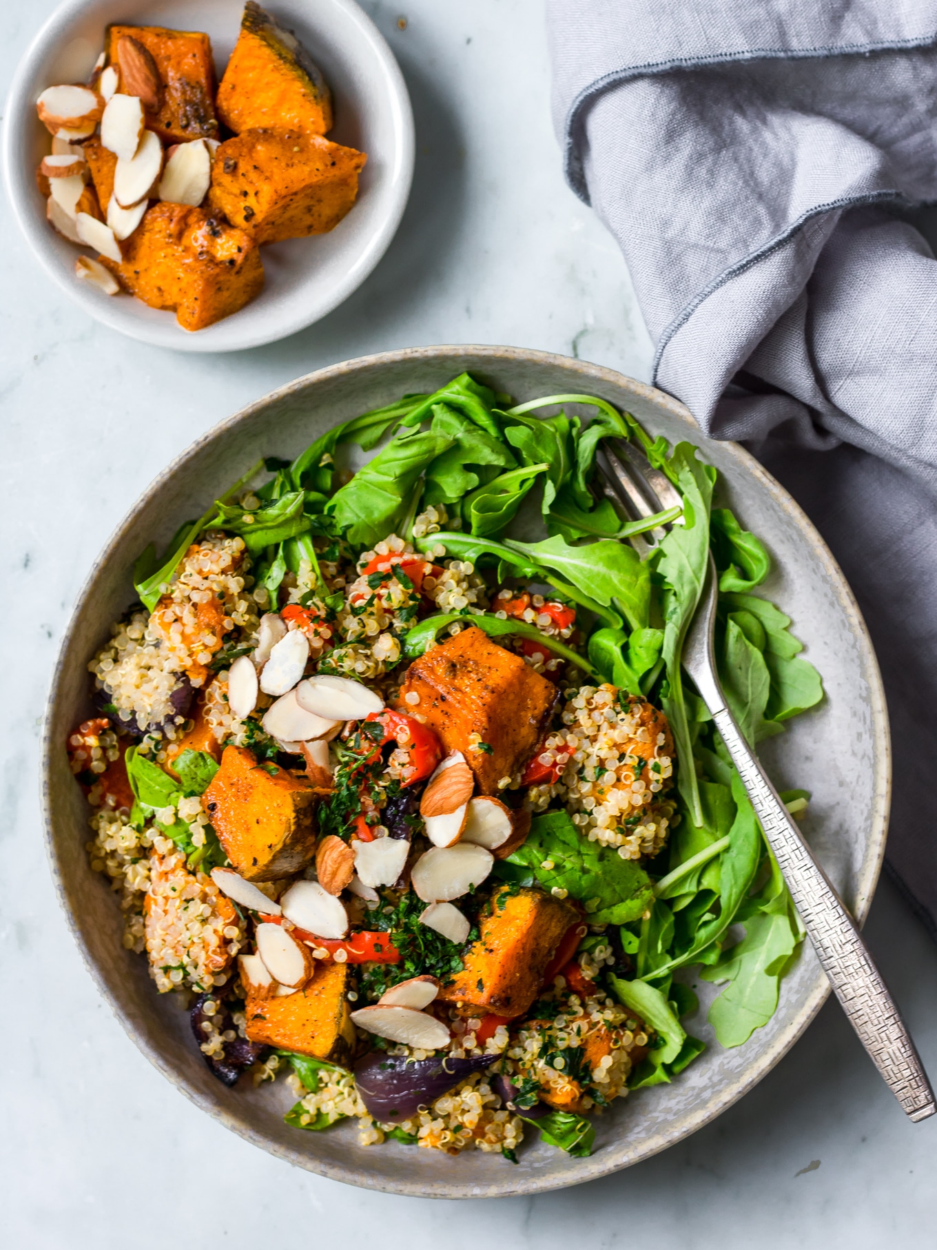 pumpkin quinoa salad flat lay view, grey bowl, grey napkin, roast pumpkin in side dish