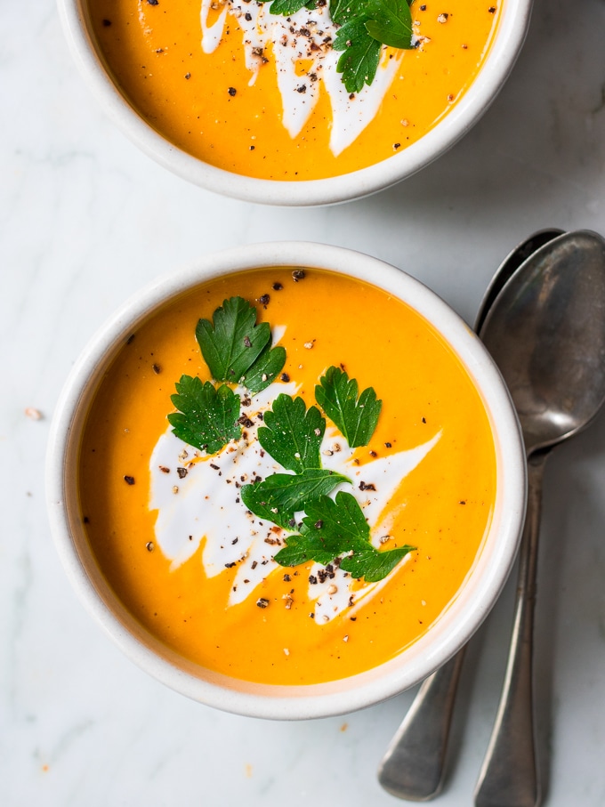 coconut ginger pumpkin soup bowl garnished with coconut cream and herbs