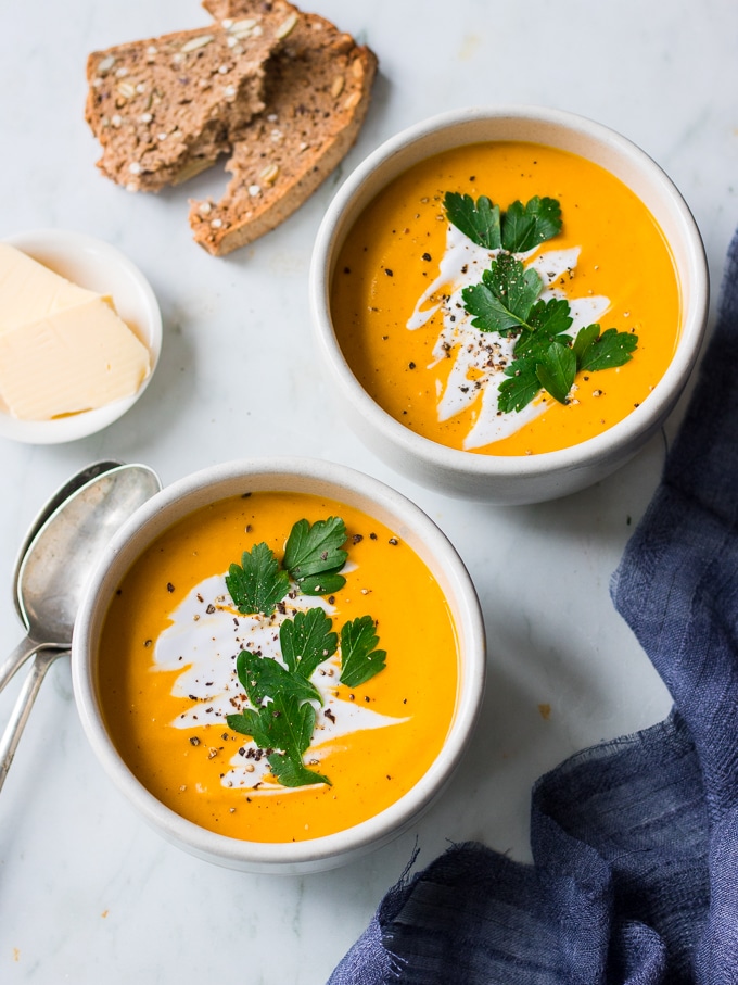 coconut ginger pumpkin soup bowl garnished with coconut cream and herbs