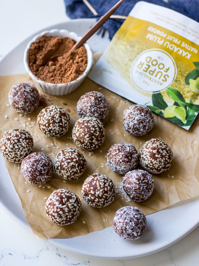 kakadu plum and ginger energy balls on white plate with australian superfoods kakadu plum powder