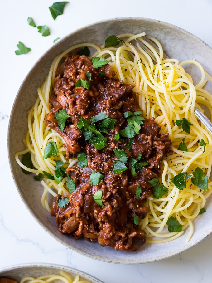 Red Wine Bolognese in ceramic bowl, spaghetti, parsley garnish