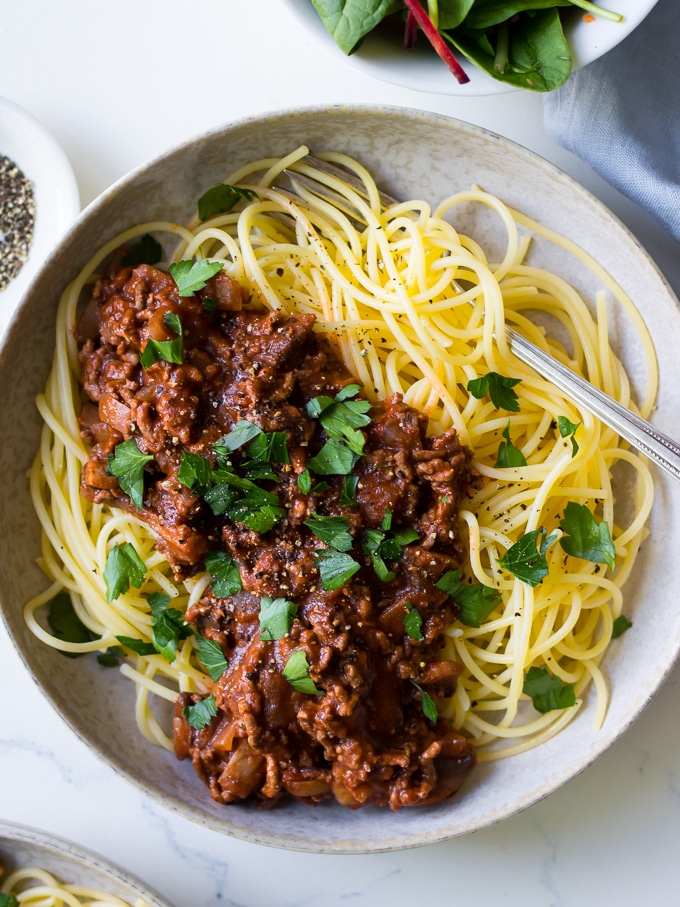 Red Wine Bolognese in ceramic bowl, spaghetti, parsley garnish