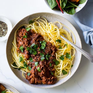 Red Wine Bolognese in ceramic bowl, spaghetti, parsley garnish