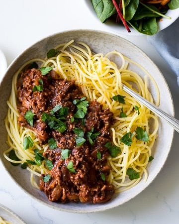 Red Wine Bolognese in ceramic bowl, spaghetti, parsley garnish