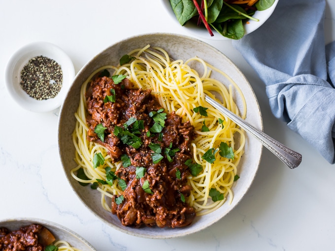 Red Wine Bolognese in ceramic bowl, spaghetti, parsley garnish