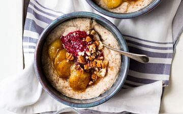 creamy quinoa porridge in blue ceramic bowls with berries and banana