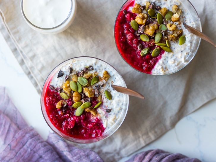 raspberry kefir overnight oats top view, in glasses with crunchy toppings