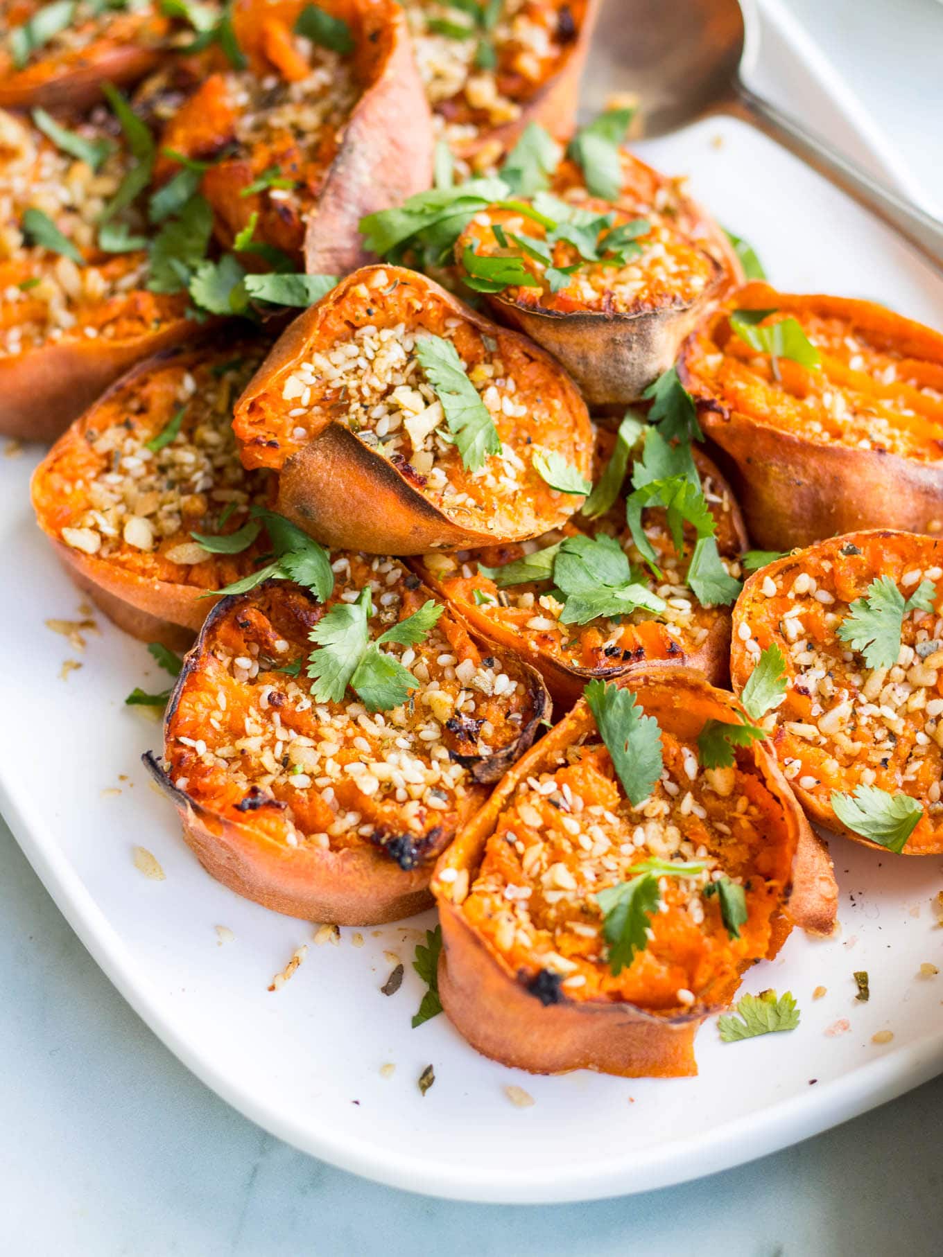 smashed sweet potatoes with dukkah on white serving platter