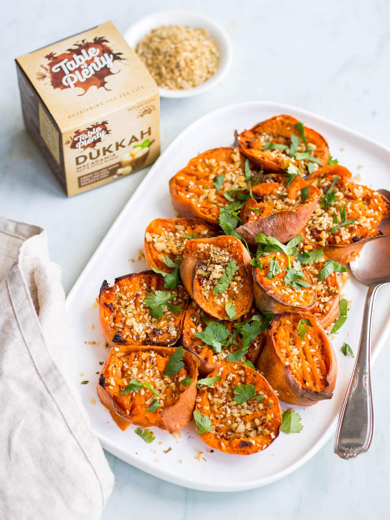 smashed sweet potatoes with dukkah on white serving platter