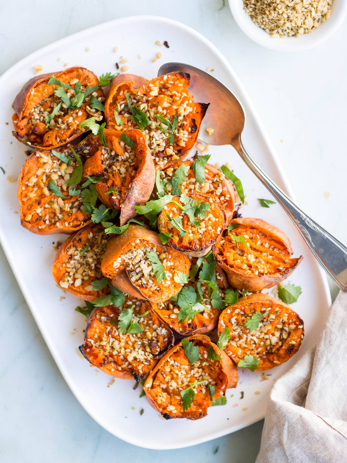 Smashed Sweet Potatoes with Dukkah on white serving dish