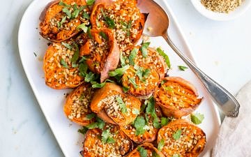 smashed sweet potatoes with dukkah on white serving platter
