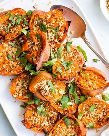 smashed sweet potatoes with dukkah on white serving platter