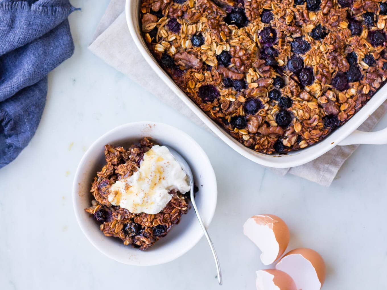 coconut blueberry baked oats with Greek yoghurt dish and serving bowl