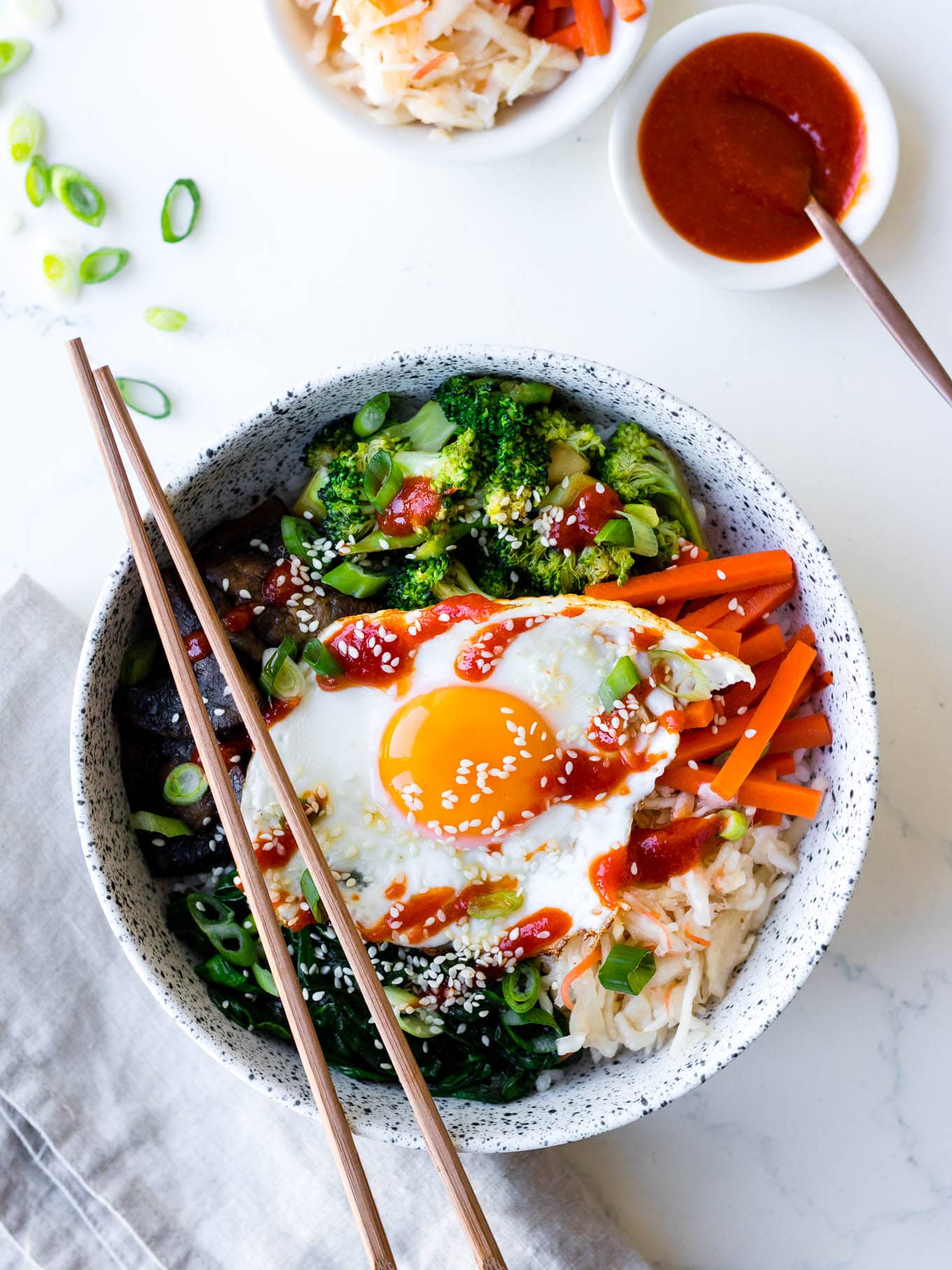 vegetarian bibimbap bowls in white ceramic bowl with pickles