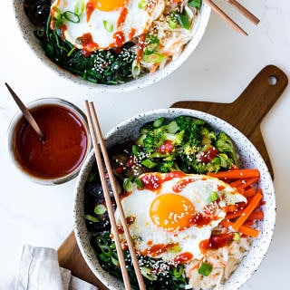 vegetarian bibimbap bowls in white ceramic bowl with pickles