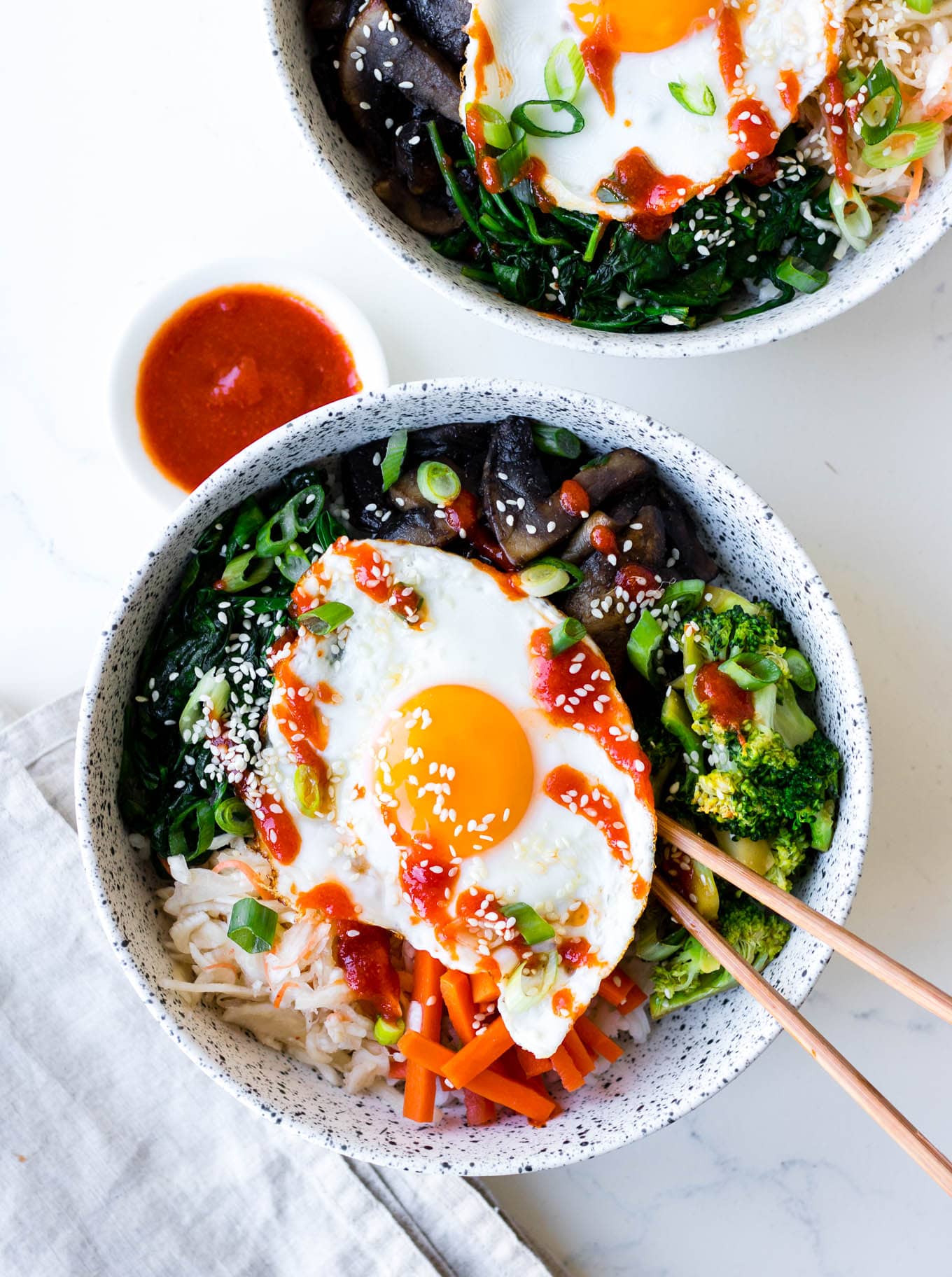 vegetarian bibimbap bowls in white ceramic bowls with pickles