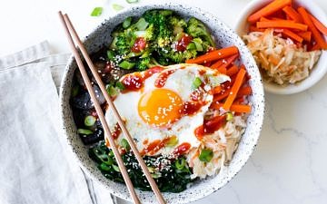 vegetarian bibimbap bowls in white ceramic bowl with pickles