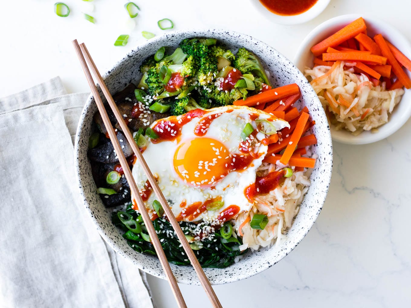 vegetarian bibimbap bowls in white ceramic bowl with pickles
