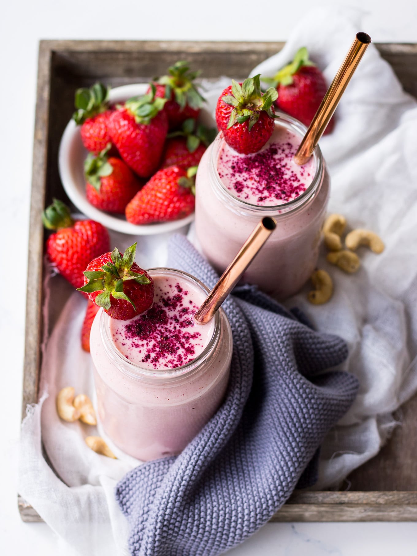 strawberry shortcake smoothie recipe, strawberry smoothies in jars on wooden tray