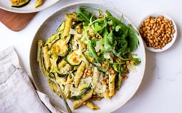 Pesto Pulse Pasta with Roasted Zucchini served in a grey ceramic bowl, with pine nuts