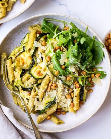 Pesto Pulse Pasta with Roasted Zucchini served in a grey ceramic bowl, with pine nuts