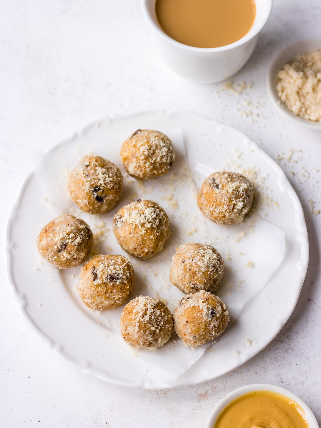 No bake Lactation Bites arranged on a white plate, scattered with almond meal