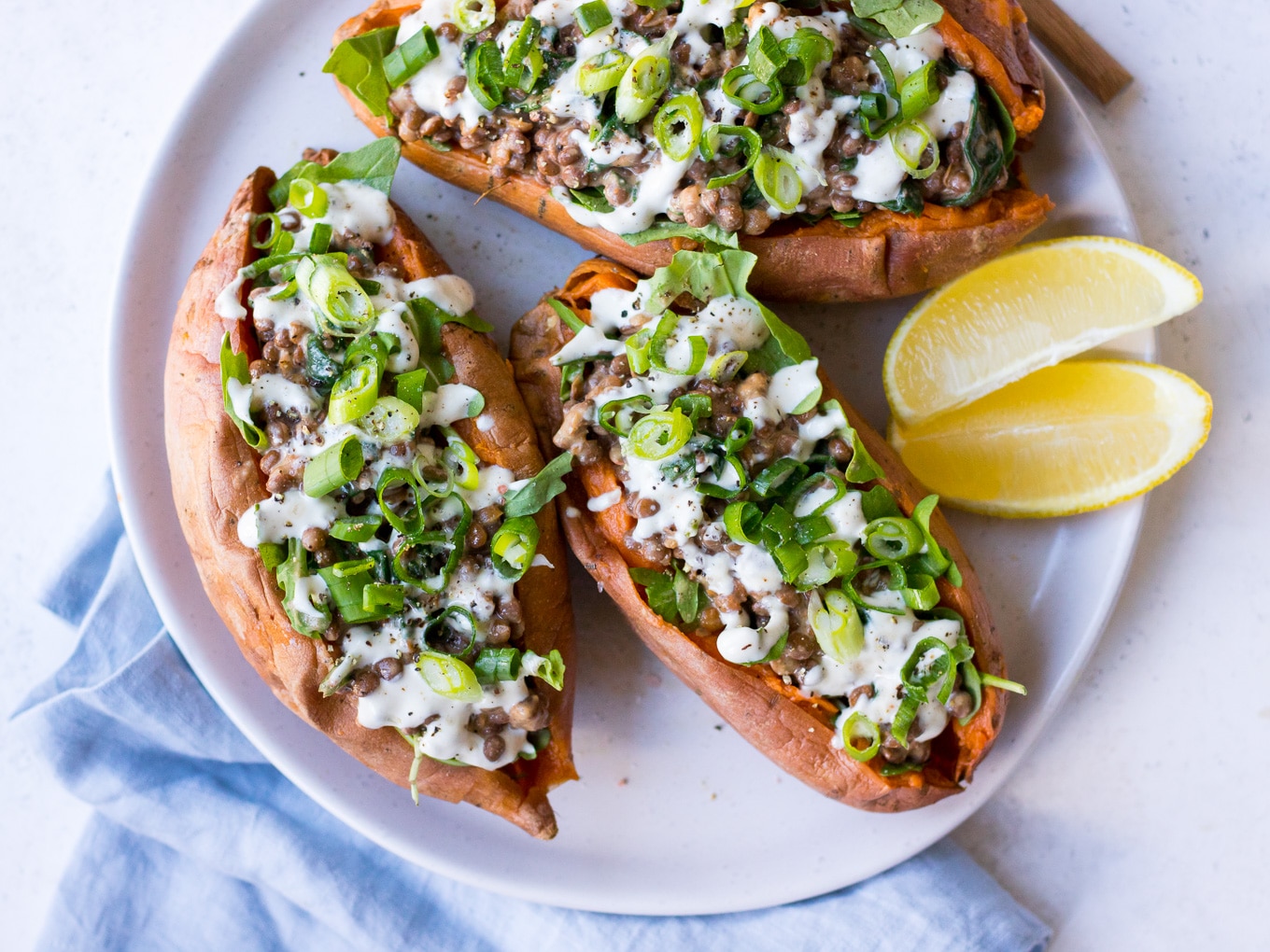 Vegan Stuffed Sweet Potatoes with creamy lentils, greens, tahini and spring onion