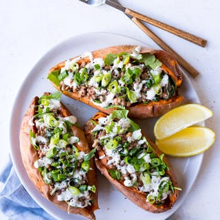 Vegan Stuffed Sweet Potatoes with creamy lentils, greens, tahini and spring onion