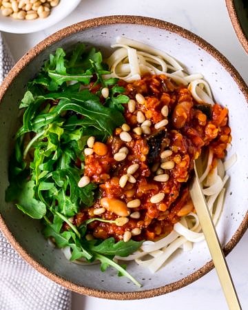 Vegan bolognese sauce topped with pine nuts