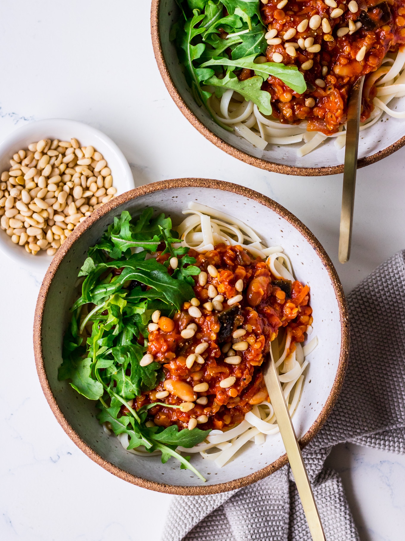 Bowls of pasta with vegan red lentil bolognese sauce and greens (Nourish Every Day)