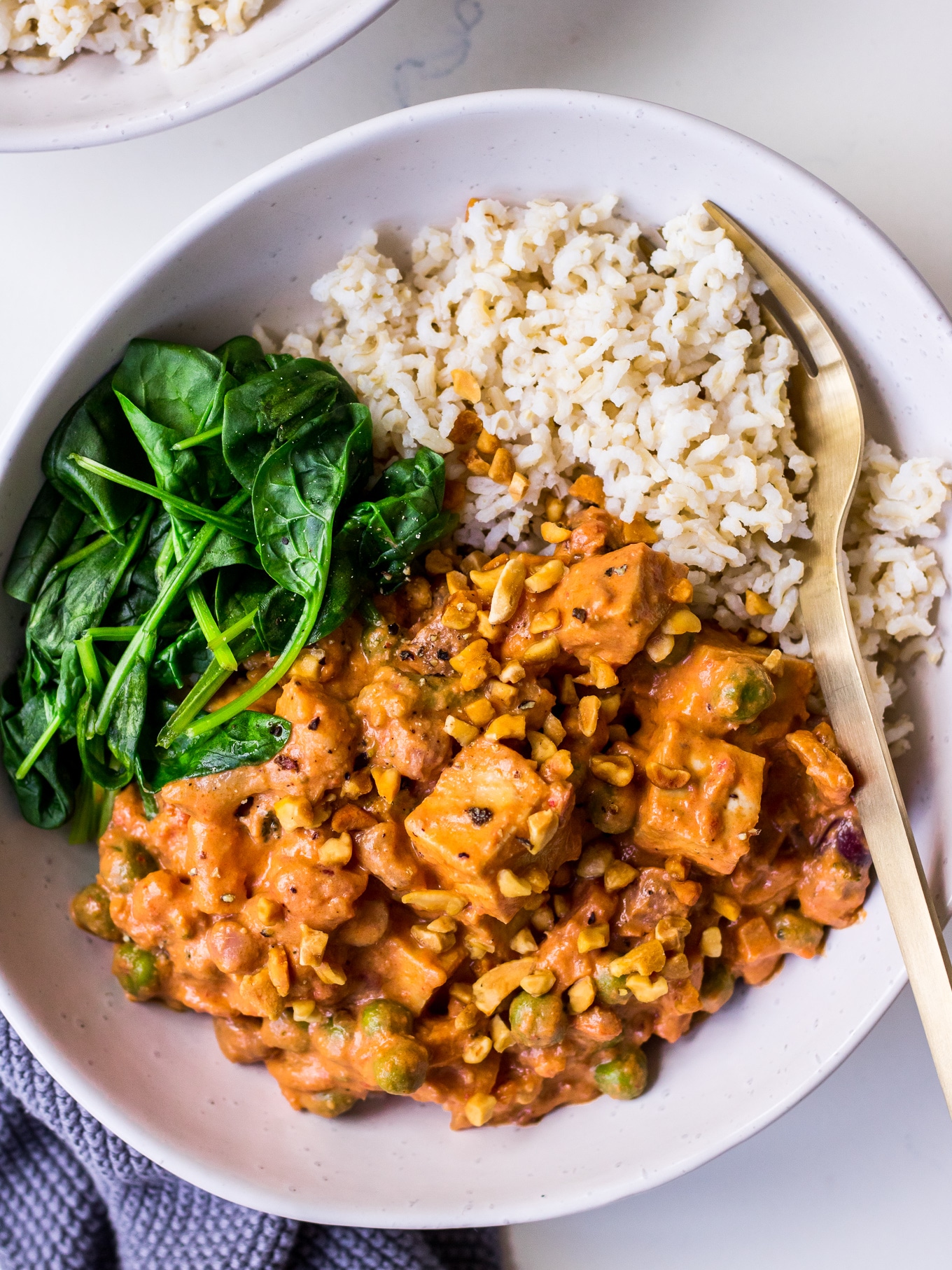 Bowl with peanut tofu curry, spinach and brown rice