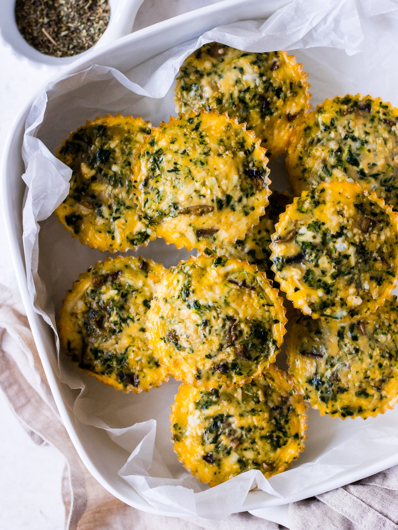 Stacked white dish of vegetable and halloumi egg muffins