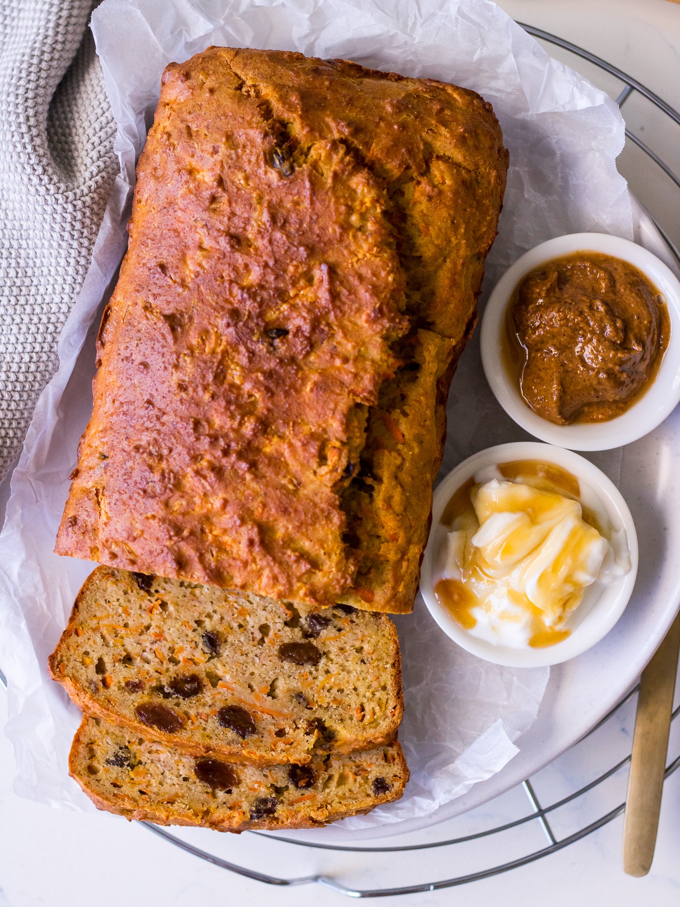 Sliced loaf cake with sultanas, ricotta and almond butter on white background