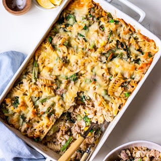 Creamy tuna pasta bake flat lay with bowl and condiments
