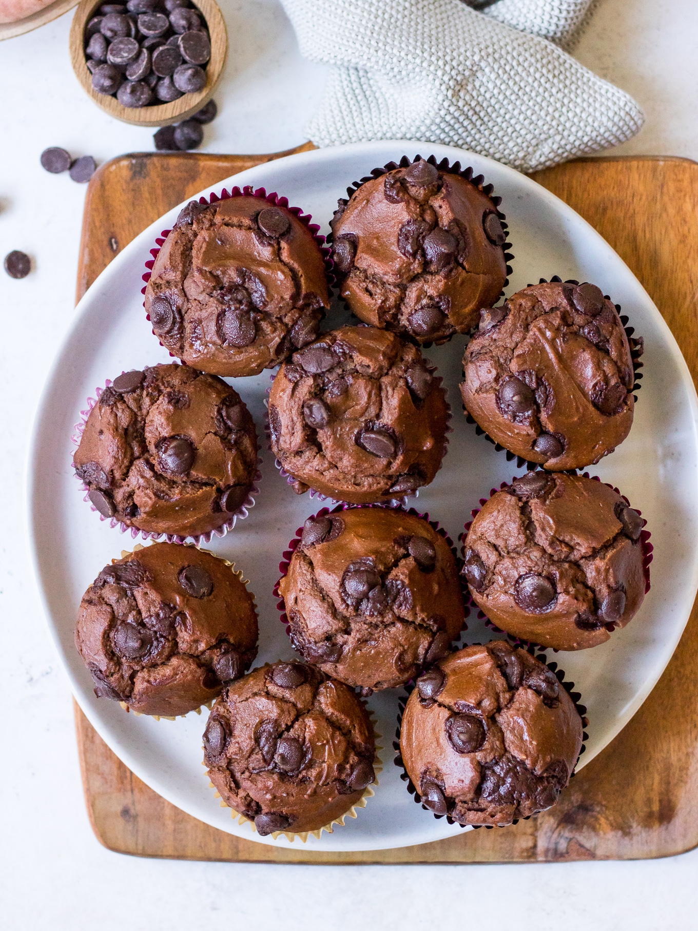 Top view of chocolate chip chocolate sweet potato muffins on white plate