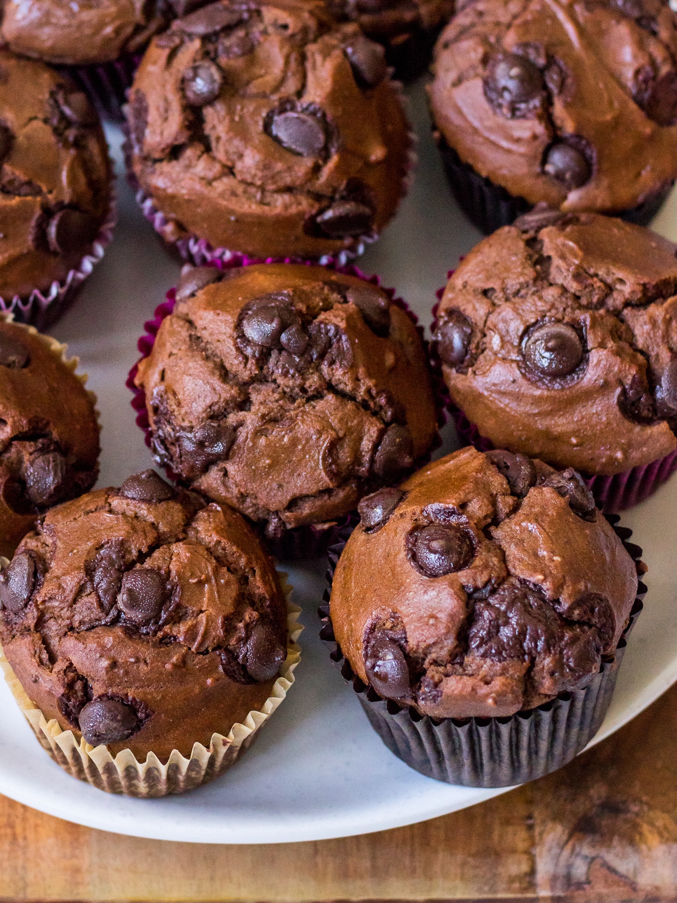 Angle view of chocolate chip chocolate sweet potato muffins on a white plate