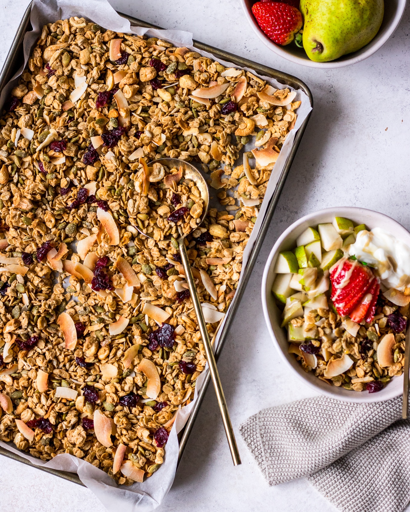 Flatlay tray of tahini granola with a side bowl filled with granola and fruit
