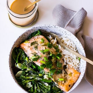 Tahini Miso Salmon in speckled white bowl with sauce jar