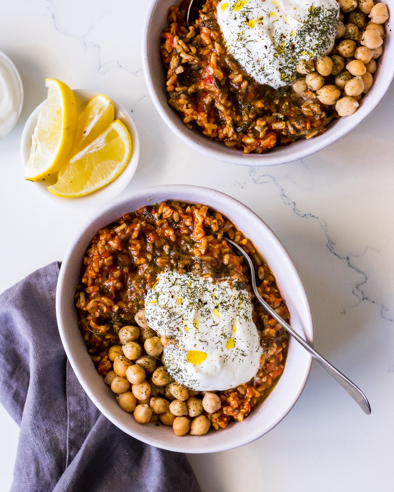 Spanakorizo (Greek spinach and rice) in a white bowl with chickpeas, yoghurt, lemon and herbs