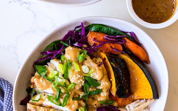 Irregular white bowls with rice, pumpkin, cabbage, chicken and miso dressing with herbs