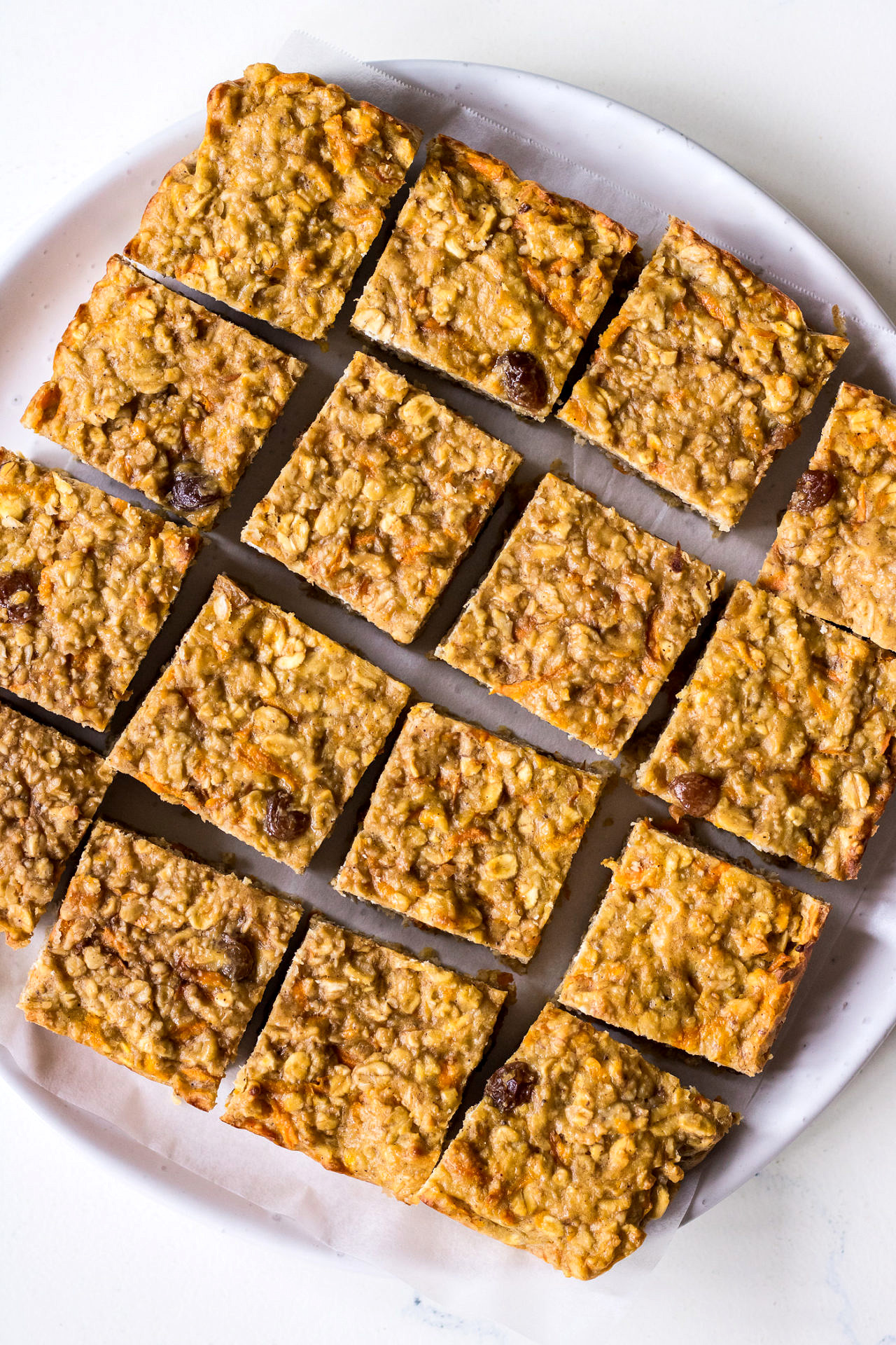 Round white plate filled with square oatmeal bars
