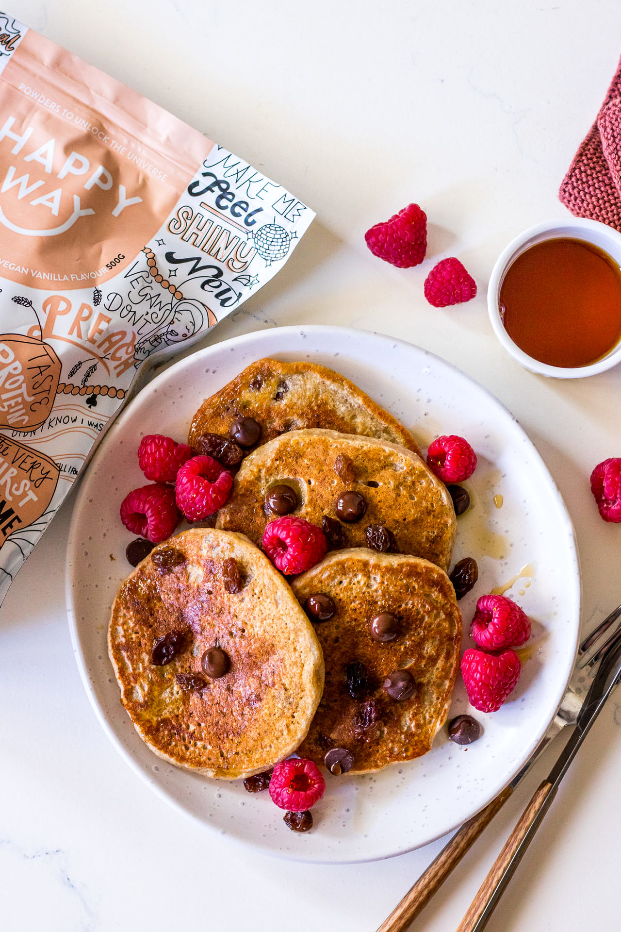 Close up of vegan protein pancakes with berries and maple syrup